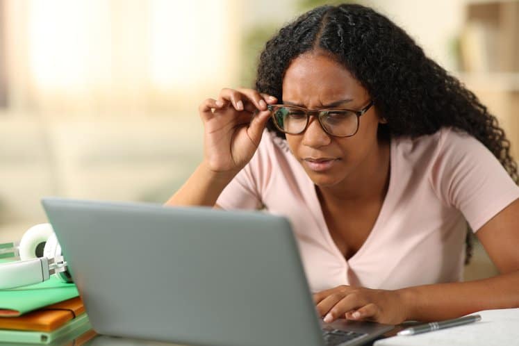 Student forcing sight in front of a computer.